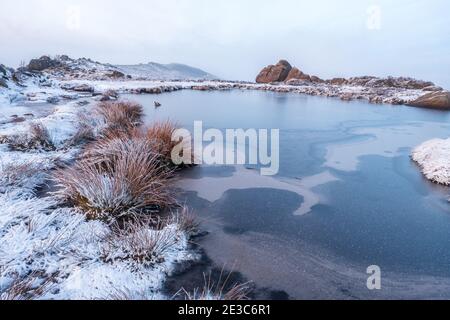 The frozen Doxeys Pool on the Roaches ridge in the Staffordshire Moorlands area of the Peak District National Park, UK Stock Photo