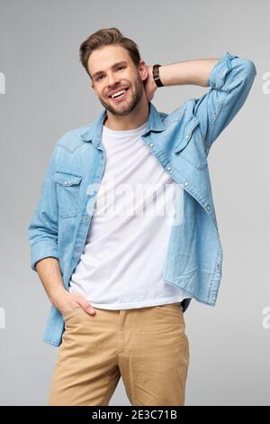 Portrait of young handsome caucasian man in jeans shirt over light background Stock Photo