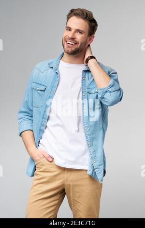 Portrait of young handsome caucasian man in jeans shirt over light background Stock Photo