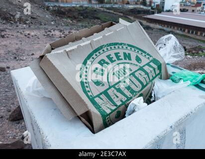 100% green, natural pizza box packaging in litter bin with plastic bags. Stock Photo