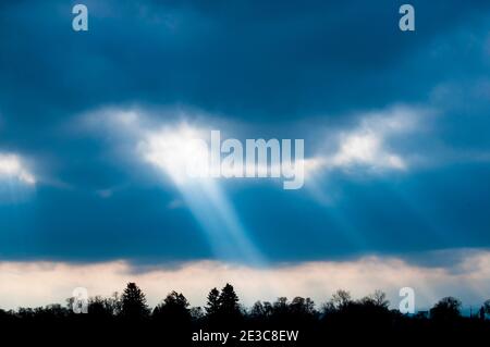 heavenly divine rays of lights from behind clouds Stock Photo
