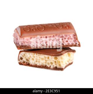 Mix of porous chocolate pieces isolated on white background. White and pink aerated chocolate. Stock Photo