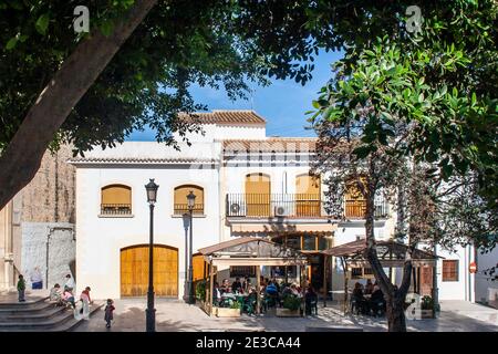 Chairs and tables set outside araditional Spanish bar in the church square on a sunny summer day at San Roc in Oliva in the Valencian region of Spain Stock Photo