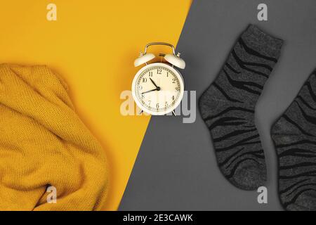 Creative composition yellow and gray colors of the year 2021, two color clothes on flat background and alarm clock photo Stock Photo