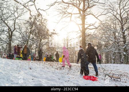 Kyiv, Ukraine, January 15 2021, children with sleds having fun in winter park an a sunny day Stock Photo