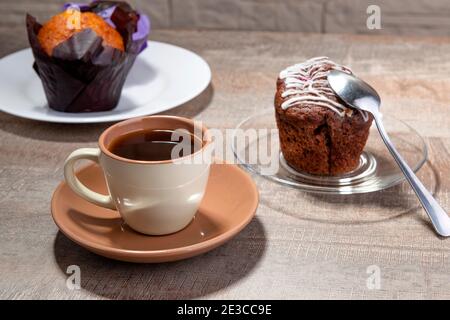 Coffee cup and cupcakes on the wooden table for breakfast Stock Photo