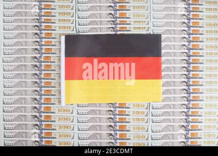 Germany flag on a background from dollar banknotes. Concept of the relationship of the German money in relation to the dollar, the country's economy, Stock Photo
