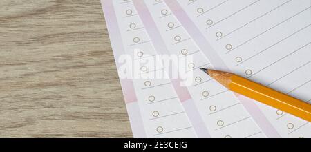 Close-up of pencil on empty white lined paper blanks. Wooden table background. Top view. Stock Photo