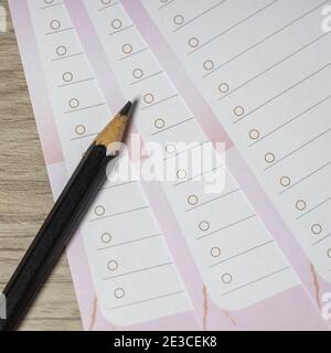 Close-up of pencil on empty white lined paper blanks. Wooden table background. Top view. Stock Photo