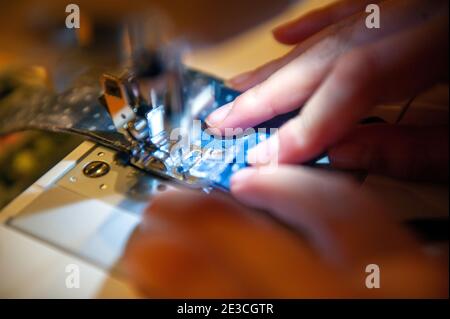 Close-up of a girl using a sewing machine Stock Photo