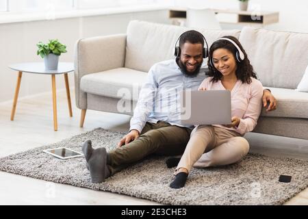 Black man and woman having videocall using laptop waving hand Stock Photo
