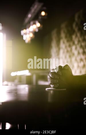 Folded hands on the top of a bar table.  Shot in ultraviolet light. Stock Photo