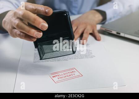 woman put a intellectual property stamp on document. copyright concept Stock Photo