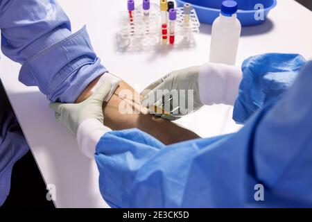 nurse injecting syringe in patient arm for blood donation or transfusion Stock Photo