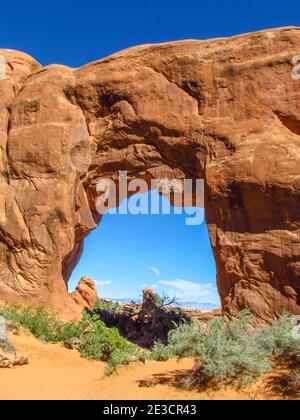 Looking through pine tree arch, one of the smaller arches in the Devil Gardens area of Arches National park, Utah, USA Stock Photo