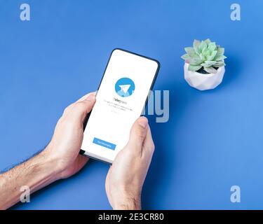 Melitopol, Ukraine - January 18 2021: Telegram application icon on smartphone screen. Online secure social media network. Blue background Stock Photo