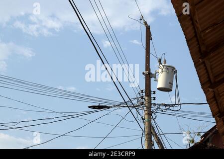 Flores, Guatemala, Central America: Cable salad/chaos on electricity pylon Stock Photo