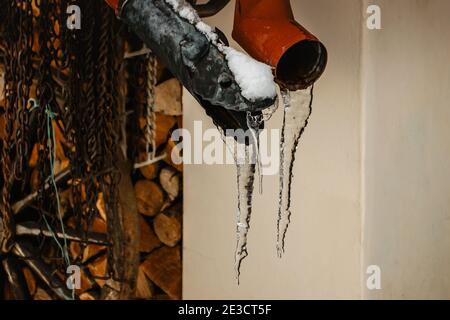 Close up of hanging icicles. Winter background with icicles. Sharp icicles and melted snow hanging from eaves of roof. Beautiful transparent icicle Stock Photo