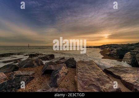 Rocks and waves at sunset on Hayling Island. Stock Photo