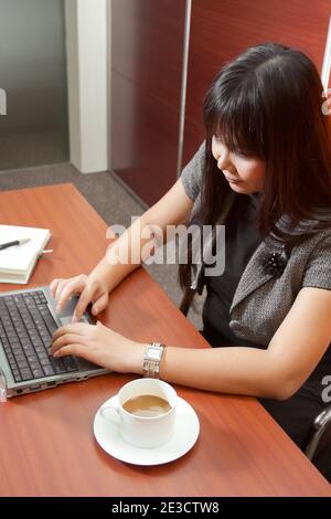 Asian business woman working at office, typing on her notebook Stock Photo