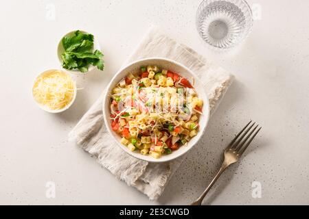 Italian salad with ditalini pasta, tomatoes, sausage on white table. View from above. Stock Photo