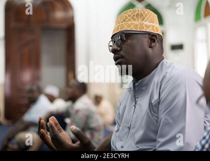 Black Muslim adult man praying inside mosque on Friday Stock Photo