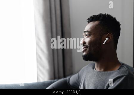 Handsome African guy with an airpods earphones Stock Photo