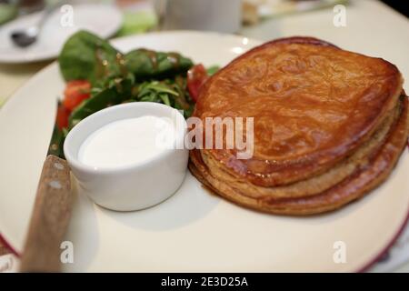 Layer Cake with veal, sour cream and green salad Stock Photo
