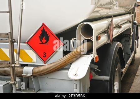 Red Warning hazmat Flammable class 3 liquid sign on back of fuel truck at petrol station Stock Photo