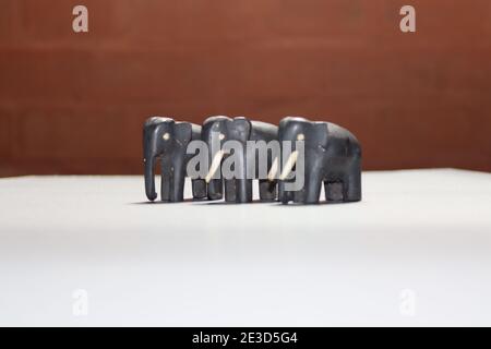 Tiny elephants by black timber made in 1960's (very old uncompleted set) Stock Photo