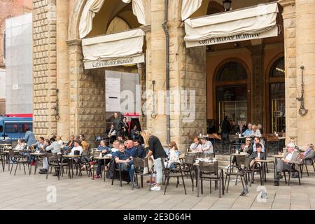 People sitting outside at tables at a cafe in the Piazza Maggiore in bologna Italy Stock Photo