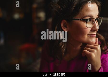 Close up of happy beautiful lady holding hand on chin while sitting in cafe Stock Photo