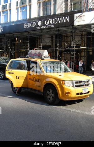 Taxi Yellow cab in New York USA Bergdorf Goodman The Mens store open door advertising advert people walking  clothes clothing person outside street Stock Photo