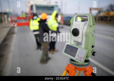 Shallow depth of field (selective focus) with a theodolite on a construction site. Stock Photo