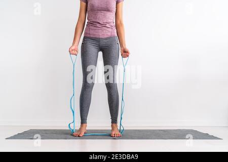 Resistance band fitness at home woman training with strap with loops for various exercises on exercise mat. Fit girl working out side bend ab muscles Stock Photo