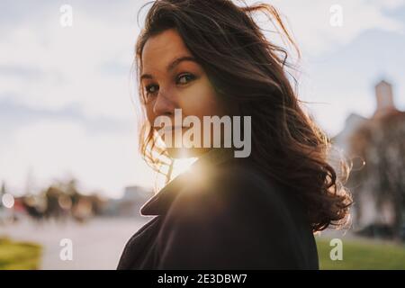Pretty smiling lady enjoying the walk in the city while posing at camera Stock Photo