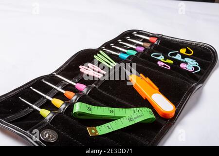 Closeup shot of various knitting tools, needles, scissors, spools, measuring tape in a bag Stock Photo