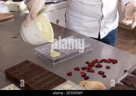 https://l450v.alamy.com/450v/2e3demy/pouring-melted-white-chocolate-into-plastic-molds-close-up-2e3demy.jpg