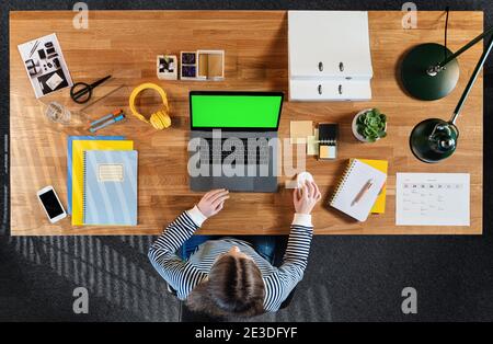 Top view of businesswoman working on computer at desk with keyable screen in home office. Stock Photo