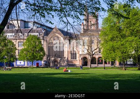 People sit outdoors in socially distanced household groups on Bristol's College Green park during the Covid-19 pandemic. Stock Photo