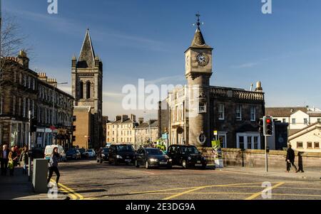 Sun shines on traditional shop, office and appartment buildings on the main Deanhaugh Street in the Edinburgh neighbourhood of Stockbridge. Stock Photo