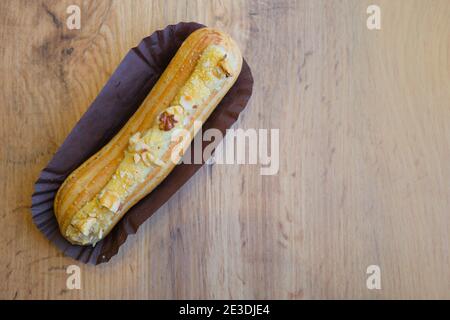 Top view traditional french chocolate eclair on wooden table, copy space Stock Photo