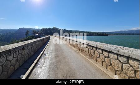 Road over the Marathon lake dam near Marathon, Greece Stock Photo