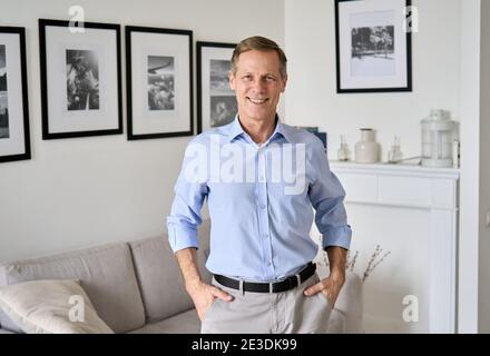 Smiling elegant 60s senior man standing at home looking at camera, portrait. Stock Photo
