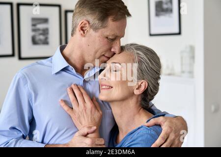Happy older affectionate couple hugging, enjoying sweet tender moment of love. Stock Photo