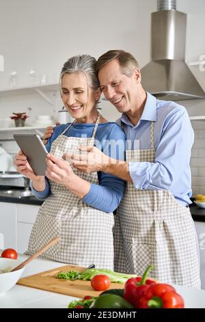 Senior couple preparing salad using tablet ordering food in grocery e shop. Stock Photo