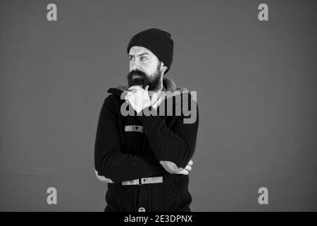 Fashion menswear shop. Masculine clothes concept. Think and decide. Winter menswear. Man bearded warm jumper and hat red background. Winter season menswear. Personal stylist. Warm and comfortable. Stock Photo