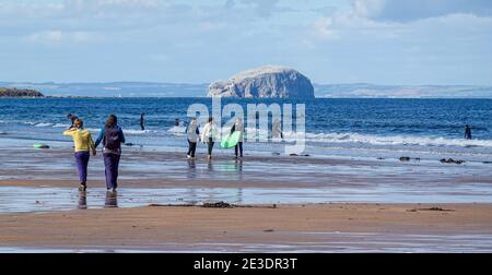 Surfers on Belhaven Beach, near Dunbar, East Lothian - Bass Rock in background Stock Photo