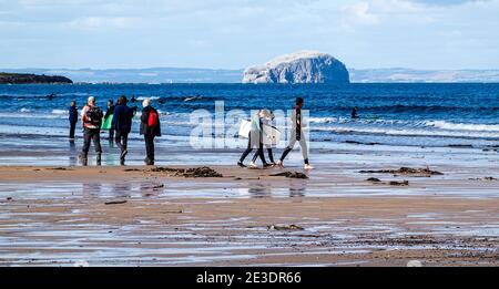 Surfers on Belhaven Beach, near Dunbar, East Lothian - Bass Rock in background Stock Photo