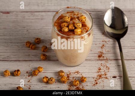Boza is a fermented malt drink made of barley, corn, wheat in Turkey and middle east. It is served with cinnamon and leblebi (roasted chickpeas) in wi Stock Photo